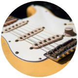 Cclose up picture of a fret board and pickup of guitar cropped in a circle