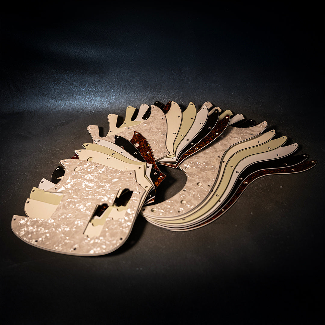 a guitar with lots of multi colored pickguards stack on top