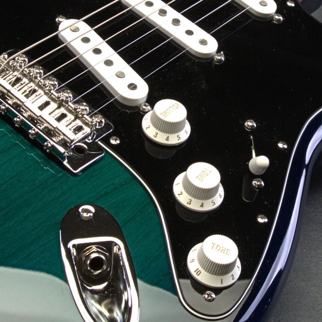 dark green guitar close up of knobs