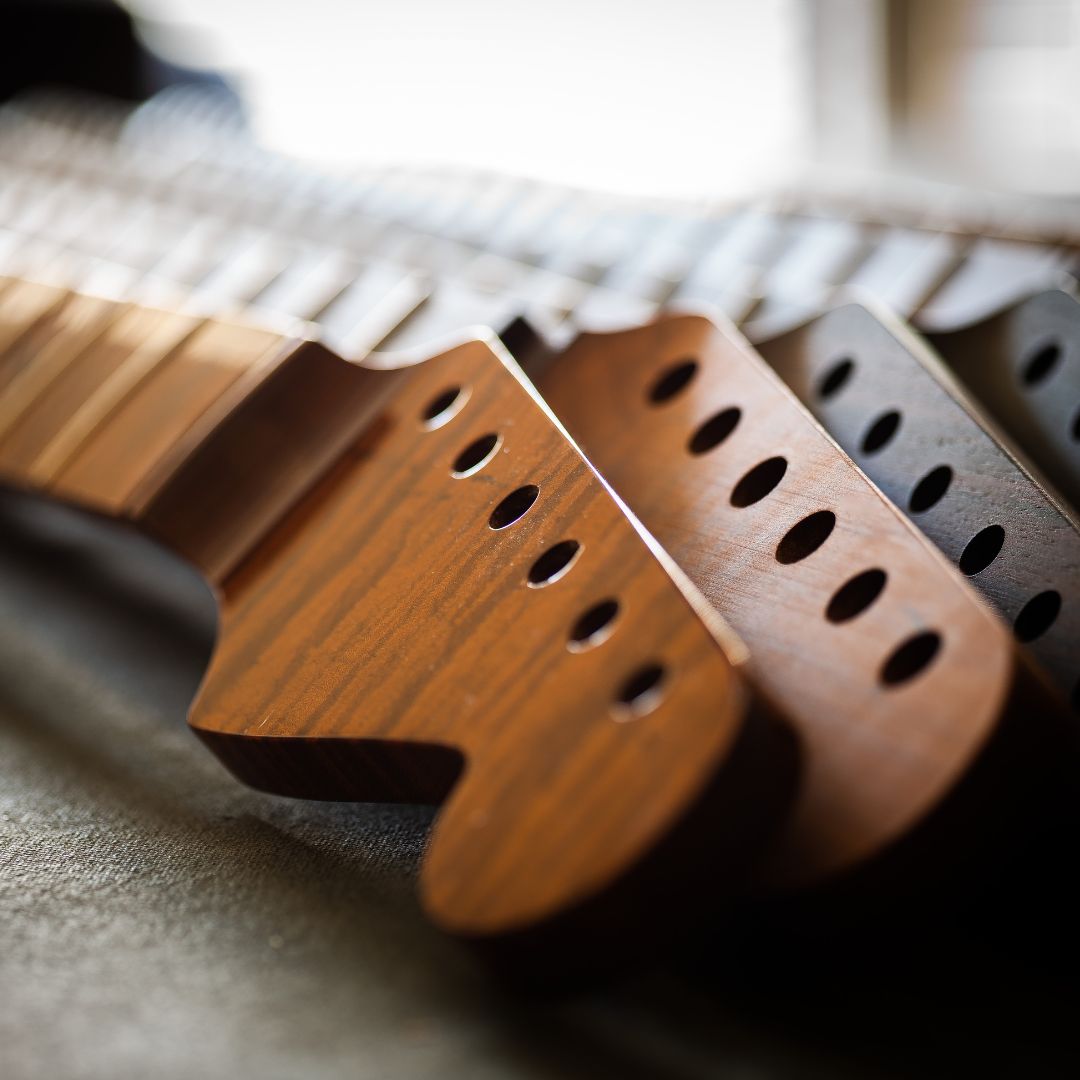 up close image of 4 strat guitar necks 