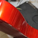 side of red guitar with clear coat