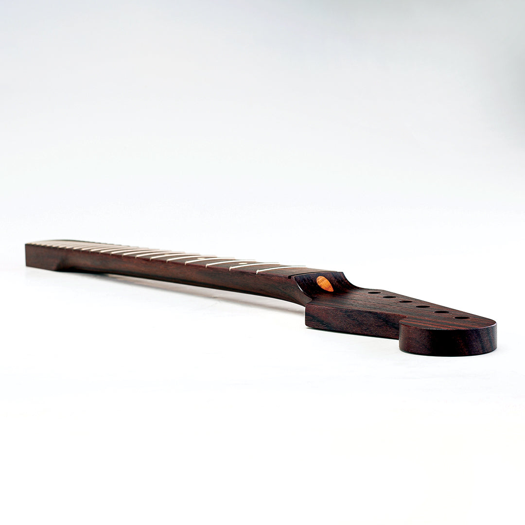 Rosewood colored guitar neck laying faced forward 