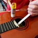 Fret shock absorber in use on acoustic guitar