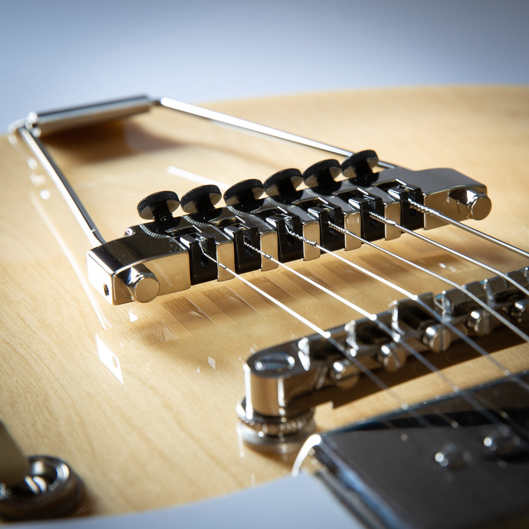 up close view of guitar strings and trapeze tailpiece