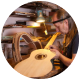 Luthier guitar repair person inspecting a guitar cropped into a circle