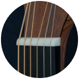 Close up picture of the neck of a guitar cropped into a circle