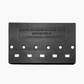 back side of black 5-string bass bridge with grooved saddles