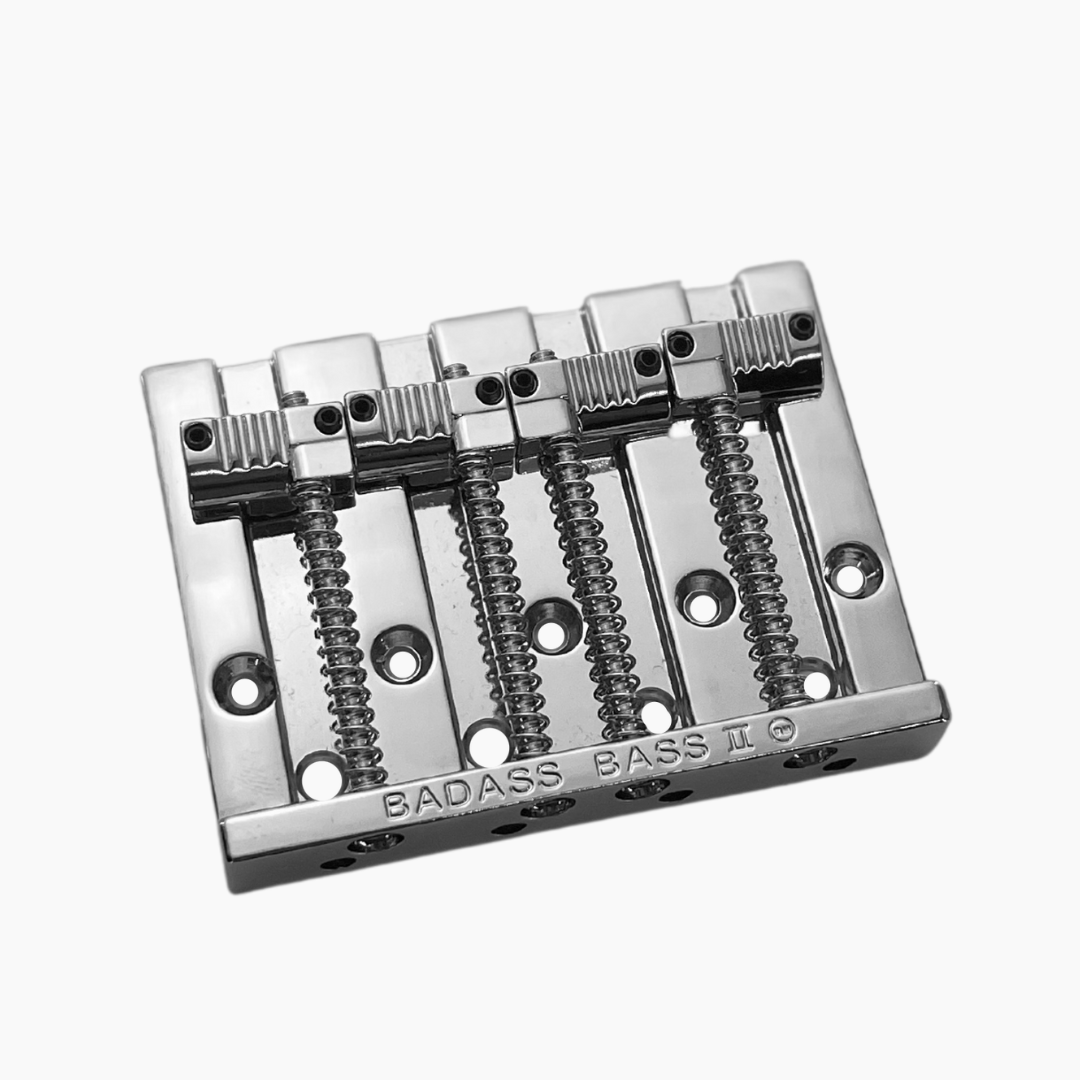 chrome angled view of 4-string bass bridge with  grooved saddles